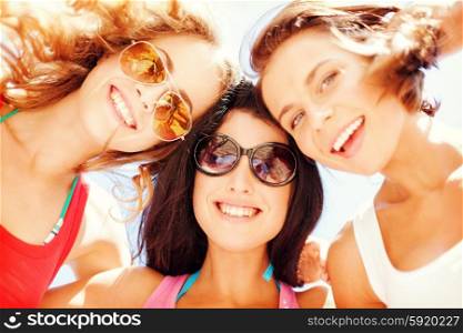 summer holidays and vacation - girls faces with shades looking down. girls faces with shades looking down