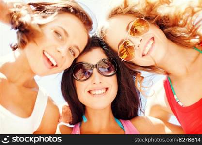 summer holidays and vacation - girls faces with shades looking down