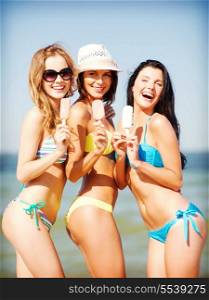summer holidays and vacation - girls in bikini with ice cream on the beach