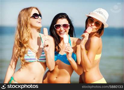 summer holidays and vacation - girls in bikini with ice cream on the beach