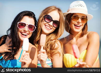 summer holidays and vacation - girls in bikinis eating ice cream on the beach. girls in bikinis with ice cream on the beach