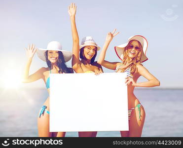 summer holidays and vacation - girls in bikinis holding blank white board on the beach. girls with blank board on the beach