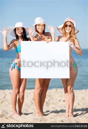summer holidays and vacation - girls in bikinis holding blank white board on the beach