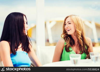 summer holidays and vacation - girls in cafe on the beach