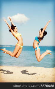 summer holidays and vacation - girls jumping on the beach