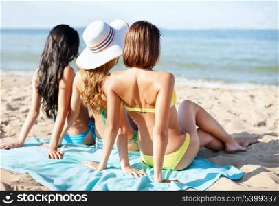 summer holidays and vacation - girls sunbathing on the beach