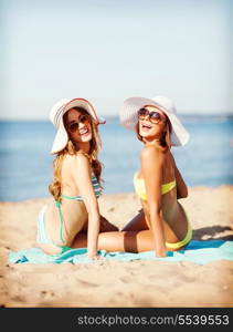 summer holidays and vacation - girls sunbathing on the beach