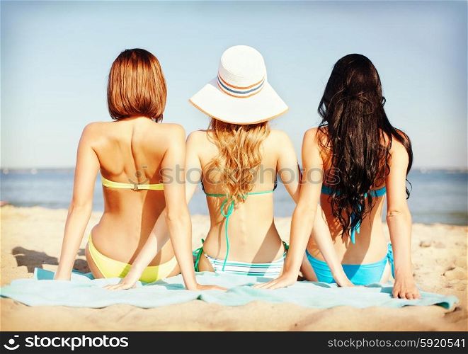 summer holidays and vacation - girls sunbathing on the beach. girls sunbathing on the beach