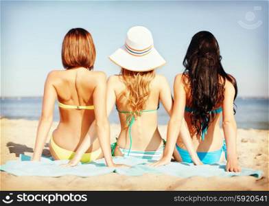 summer holidays and vacation - girls sunbathing on the beach. girls sunbathing on the beach