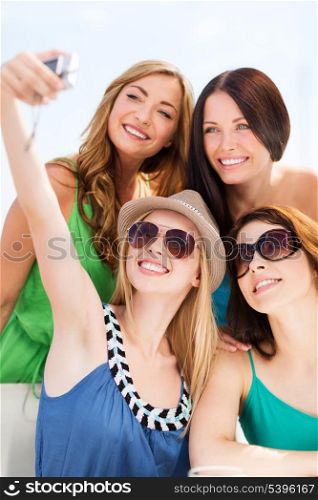 summer holidays and vacation - girls taking photo in cafe on the beach