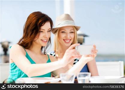 summer holidays and vacation - girls taking photo in cafe on the beach. girls taking photo in cafe on the beach
