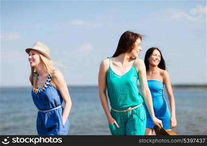 summer holidays and vacation - girls walking on the beach