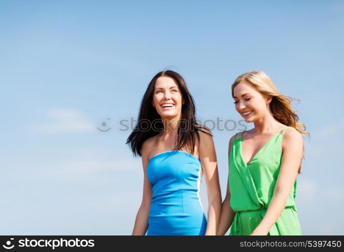 summer holidays and vacation - girls walking on the beach