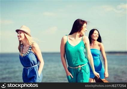 summer holidays and vacation - girls walking on the beach