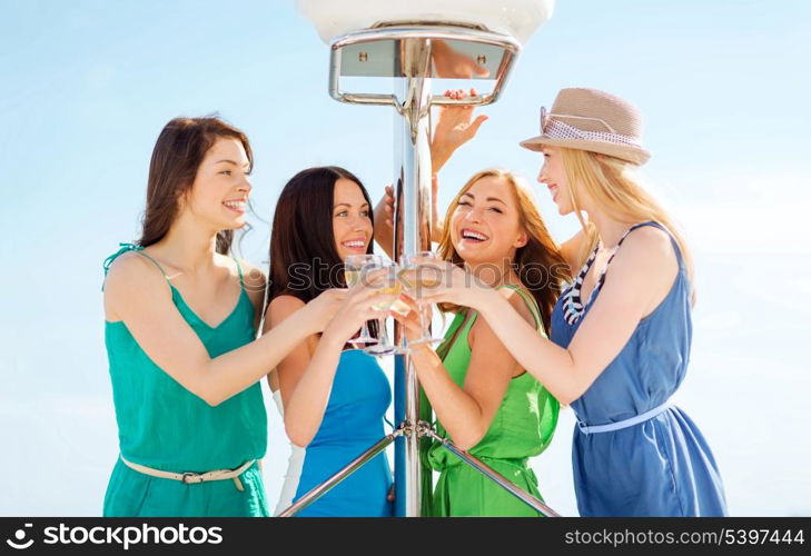 summer holidays and vacation - girls with champagne glasses on boat or yacht