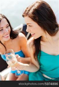 summer holidays and vacation - girls with champagne glasses on boat or yacht. girls with champagne glasses on boat
