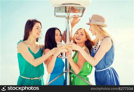 summer holidays and vacation - girls with champagne glasses on boat or yacht