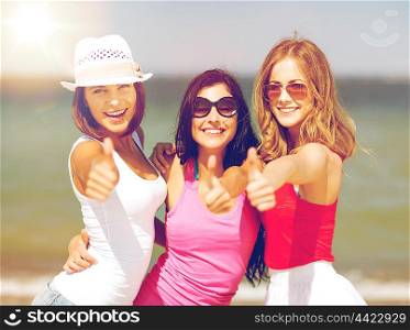 summer holidays and vacation - group of girls showing thumbs up on the beach. group of girls chilling on the beach