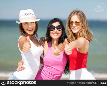 summer holidays and vacation - group of girls showing thumbs up on the beach