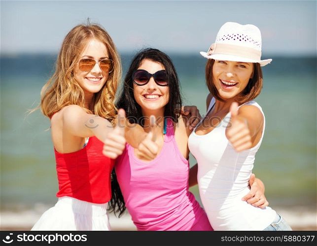 summer holidays and vacation - group of girls showing thumbs up on the beach