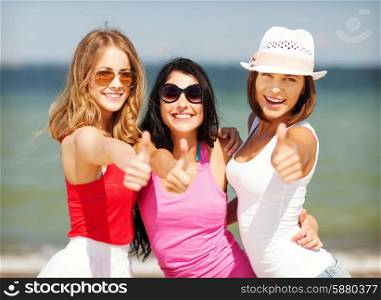 summer holidays and vacation - group of girls showing thumbs up on the beach