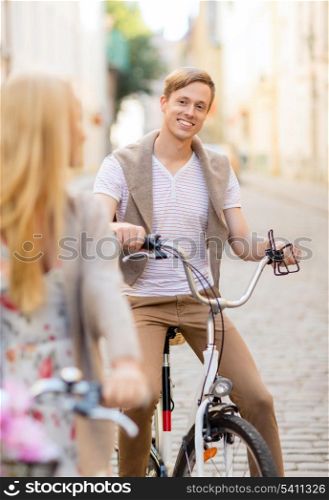 summer holidays, bikes, love, relationship and dating concept - couple with bicycles in the city