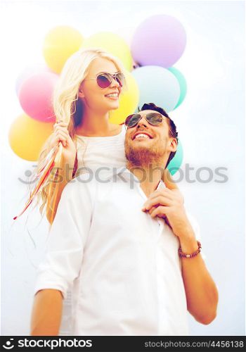 summer holidays, celebration and dating concept - couple with colorful balloons
