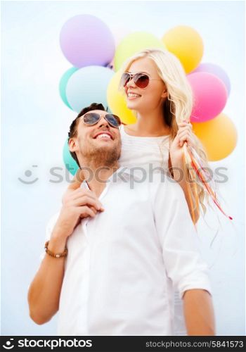 summer holidays, celebration and dating concept - couple with colorful balloons