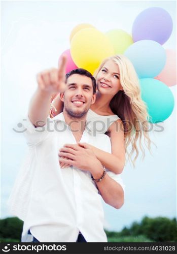 summer holidays, celebration and dating concept - couple with colorful balloons at sea side