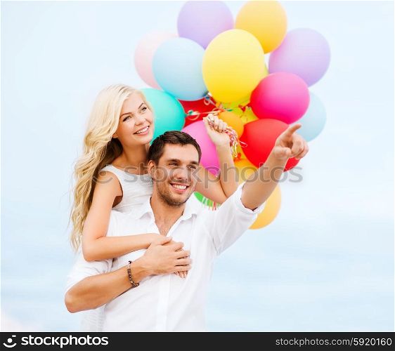 summer holidays, celebration and dating concept - couple with colorful balloons at sea side