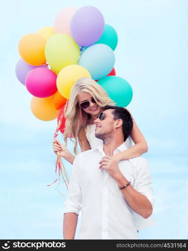 summer holidays, celebration and dating concept - couple with colorful balloons at seaside