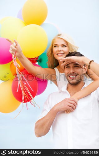 summer holidays, celebration and dating concept - couple with colorful balloons at seaside