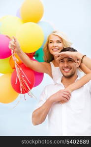 summer holidays, celebration and dating concept - couple with colorful balloons at seaside