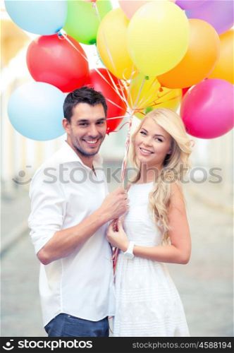 summer holidays, celebration and dating concept - couple with colorful balloons in the city