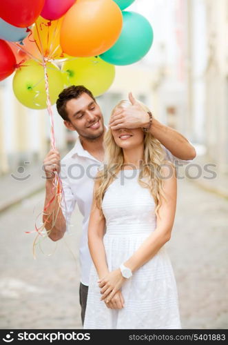 summer holidays, celebration and dating concept - couple with colorful balloons in the city