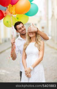 summer holidays, celebration and dating concept - couple with colorful balloons in the city