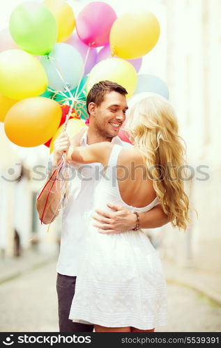 summer holidays, celebration and dating concept - couple with colorful balloons in the city