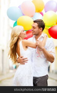 summer holidays, celebration and dating concept - couple with colorful balloons in the city