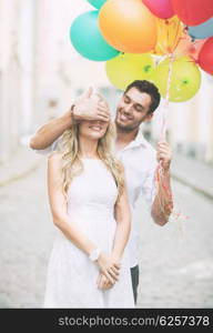 summer holidays, celebration and dating concept - couple with colorful balloons in the city