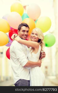 summer holidays, celebration and dating concept - couple with colorful balloons in the city