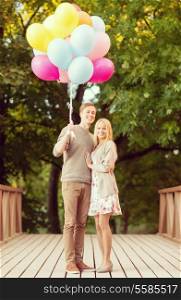 summer holidays, celebration and dating concept - couple with colorful balloons in the park