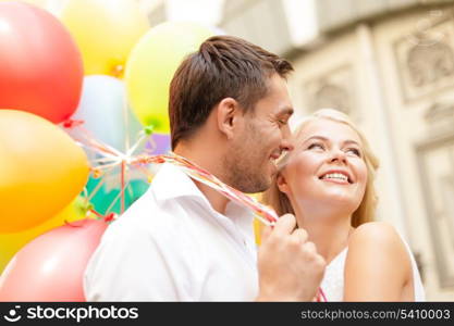 summer holidays, celebration and dating concept - happy couple with colorful balloons in the city