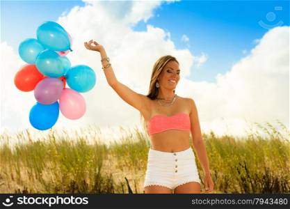 Summer holidays, celebration and lifestyle concept - attractive woman teen girl with colorful balloons outside on beach blue sky background