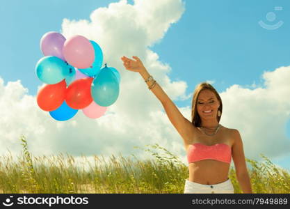 Summer holidays, celebration and lifestyle concept - attractive woman teen girl with colorful balloons outside on beach blue sky background