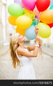 summer holidays, celebration and lifestyle concept - beautiful woman with colorful balloons in the city