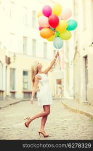 summer holidays, celebration and lifestyle concept - beautiful woman with colorful balloons in the city