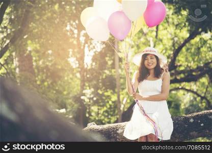 summer holidays, celebration and lifestyle concept - beautiful woman with colorful balloons outdoor in the park.