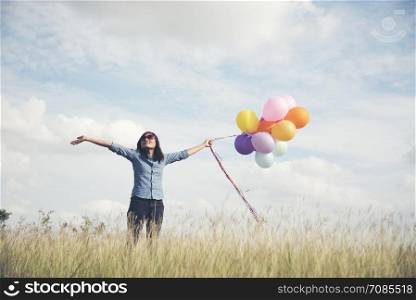 summer holidays, celebration and lifestyle concept - beautiful woman with colorful balloons outdoor in the park.