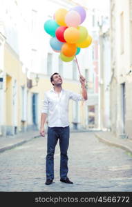 summer holidays, celebration and lifestyle concept - man with colorful balloons in the city