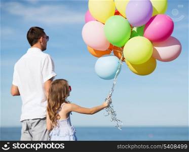 summer holidays, celebration, children and family concept - father and daughter with colorful balloons